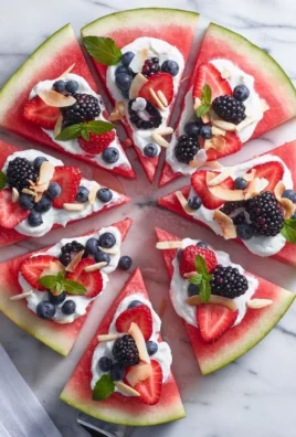 Delicious sweet watermelon pizza topped with fruits and mint leaves