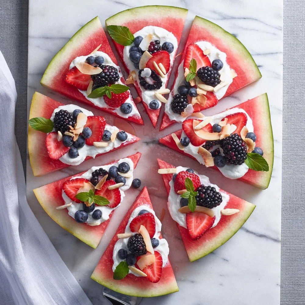 Delicious sweet watermelon pizza topped with fruits and mint leaves