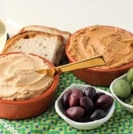 A bowl of homemade Tuna Pâté served with crackers and herbs.