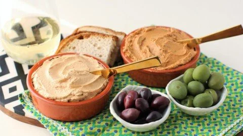 A bowl of homemade Tuna Pâté served with crackers and herbs.